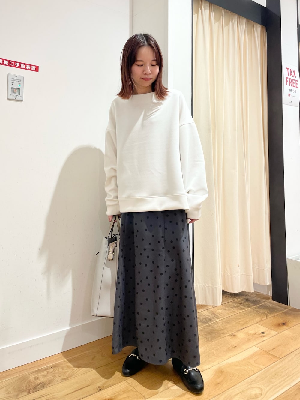 ホワイト系のTシャツ/カットソー、グレー系のスカートを着用したレディースの春コーディネートの1枚目の写真