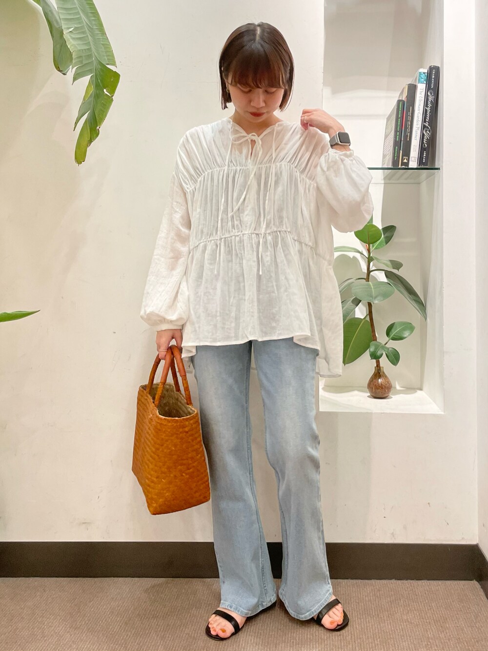 ブルー系のデニムパンツ、ブラック系のサンダル、ホワイト系のシャツ/ブラウスを着用したレディースの春コーディネートの1枚目の写真