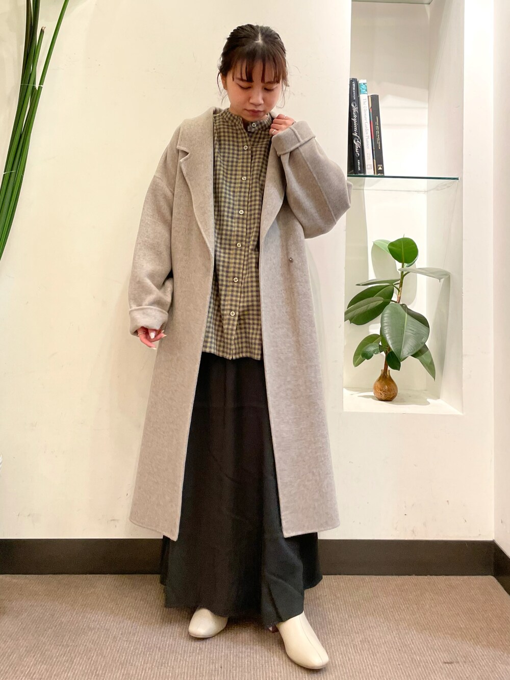 グリーン系のシャツ/ブラウス、グレー系のスカート、グレー系のチェスターコートを着用したレディースの秋コーディネートの1枚目の写真