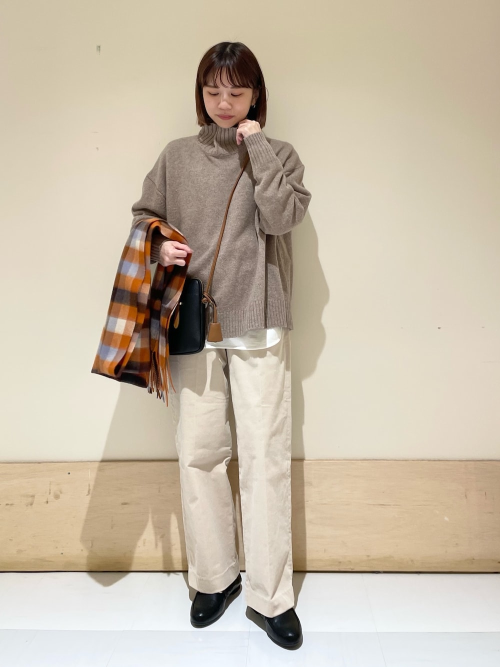 ホワイト系のTシャツ/カットソー、ブラウン系のニット/セーター、ベージュ系のその他パンツを着用したレディースの冬コーディネートの1枚目の写真