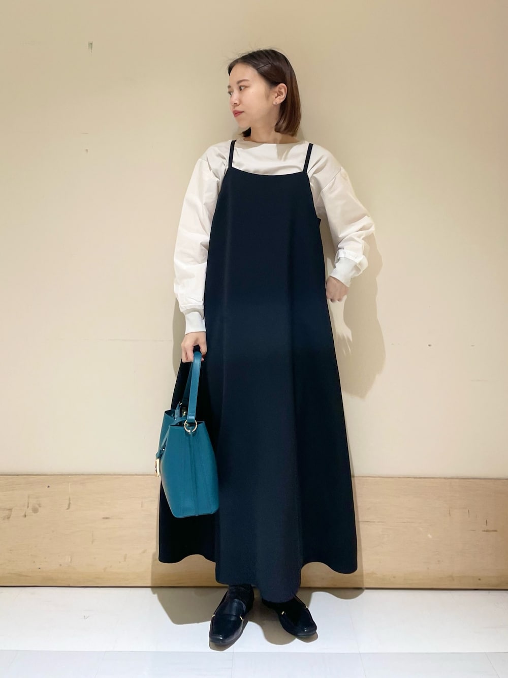 グレー系のTシャツ/カットソー、ブラック系のワンピース、ブルー系のハンドバッグを着用したレディースの秋コーディネートの1枚目の写真