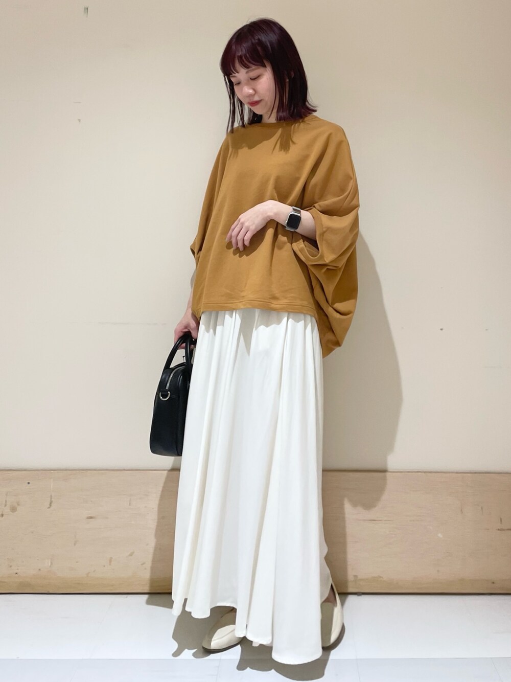 ホワイト系のスカート、イエロー系のTシャツ/カットソー、ブラック系のショルダーバッグを着用したレディースの春コーディネートの1枚目の写真