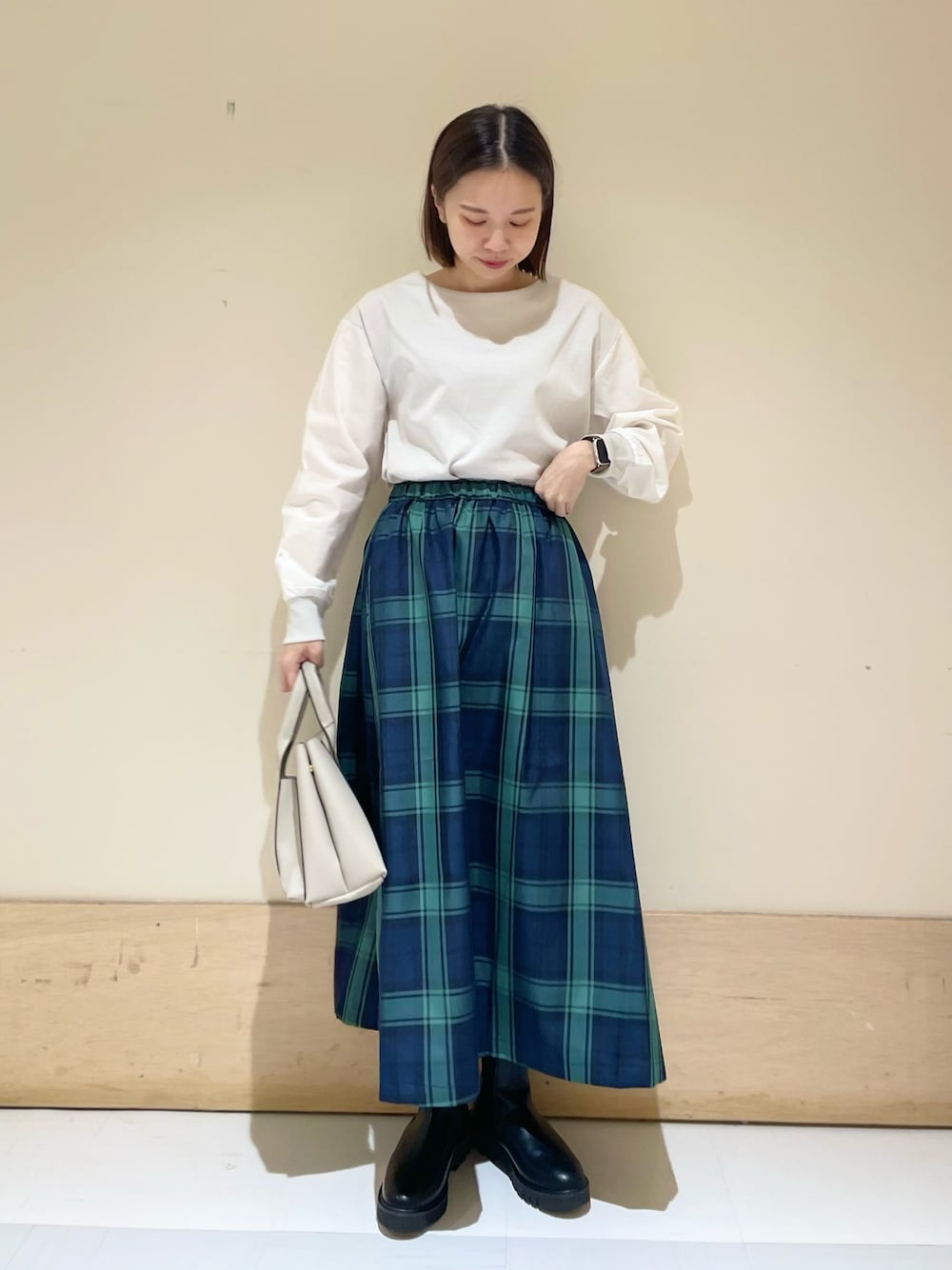 グレー系のTシャツ/カットソー、ブルー系のスカート、グレー系のトートバッグを着用したレディースの秋コーディネートの1枚目の写真