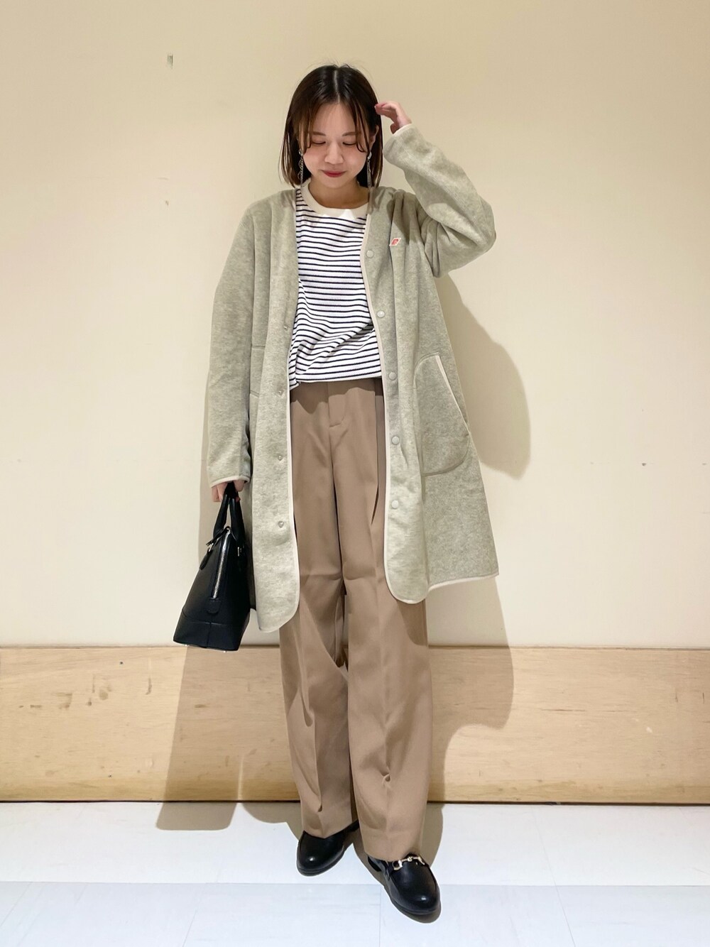 ブラック系のショルダーバッグ、ベージュ系のその他パンツ、ブラック系のローファーを着用したレディースの秋コーディネートの1枚目の写真