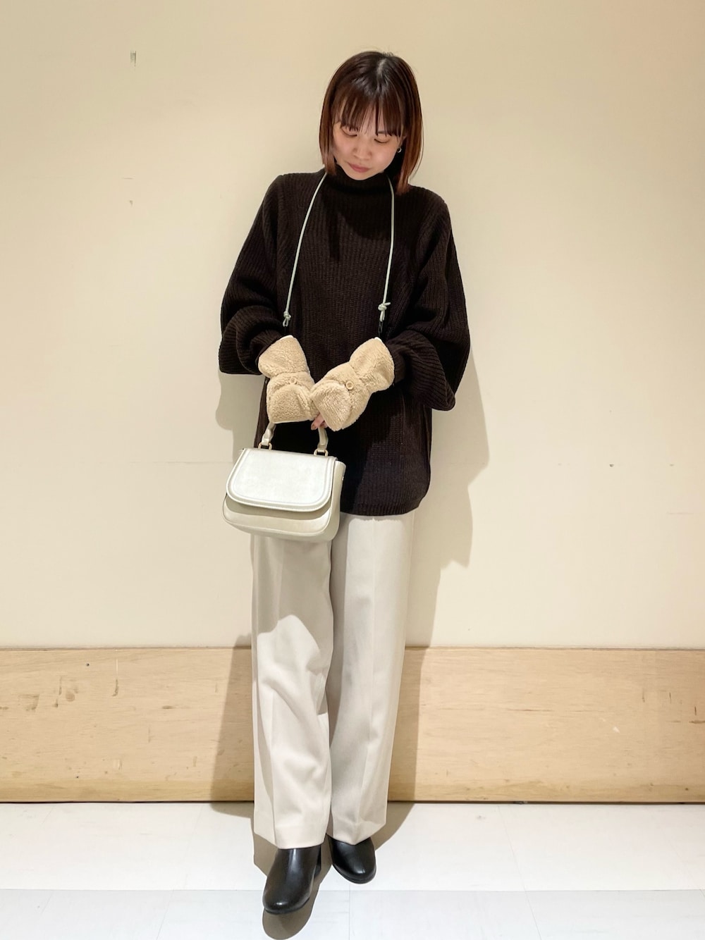 ブラウン系のニット/セーター、ゴールド系のショルダーバッグ、ホワイト系のその他パンツを着用したレディースの冬コーディネートの1枚目の写真