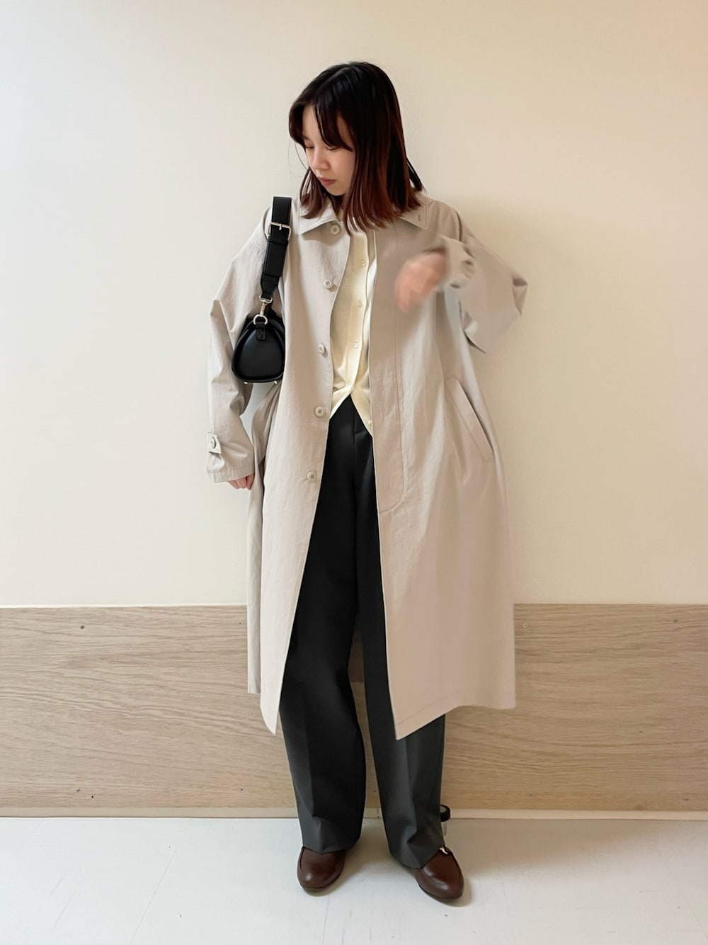 グレー系のその他パンツ、ブラック系のショルダーバッグ、グレー系のステンカラーコートを着用したレディースの春コーディネートの1枚目の写真