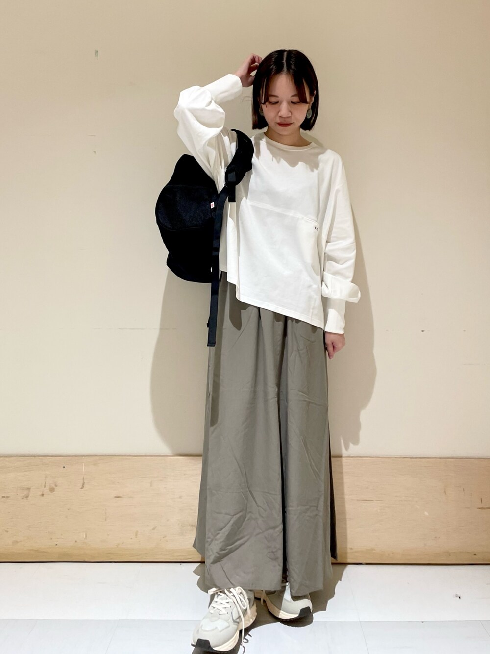 ホワイト系のTシャツ/カットソー、グリーン系のスカート、グレー系のスニーカーを着用したレディースの夏コーディネートの1枚目の写真