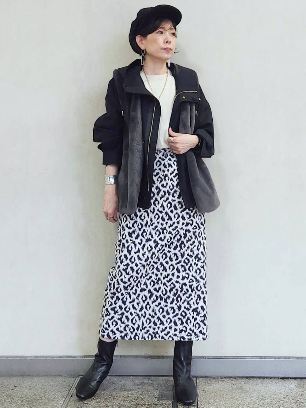 ブラック系のブルゾン、ブルー系のスカート、ブラック系のブーツを着用したレディースの秋コーディネートの1枚目の写真