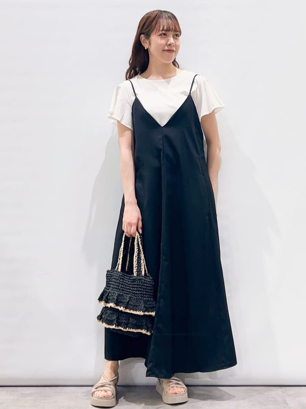 ブラック系のワンピース、ホワイト系のTシャツ/カットソー、ブラック系のトートバッグを着用したレディースの夏コーディネートの1枚目の写真
