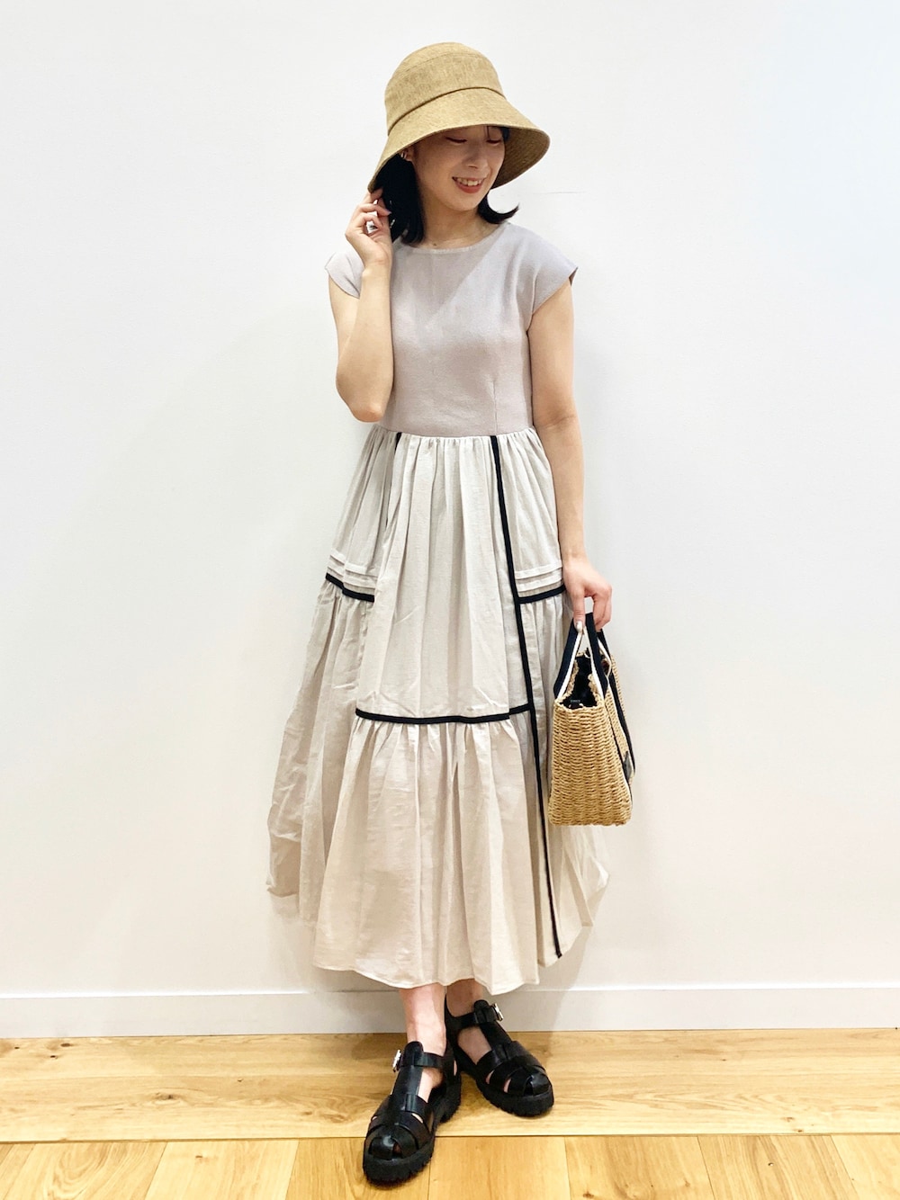 グレー系のワンピース、ブラック系のサンダル、ブラック系のトートバッグを着用したレディースの夏コーディネートの1枚目の写真