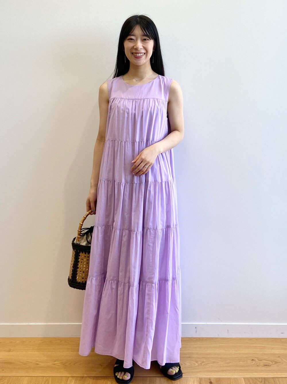 パープル系のワンピース、ブラック系のトートバッグ、ブラック系のサンダルを着用したレディースの夏コーディネートの1枚目の写真