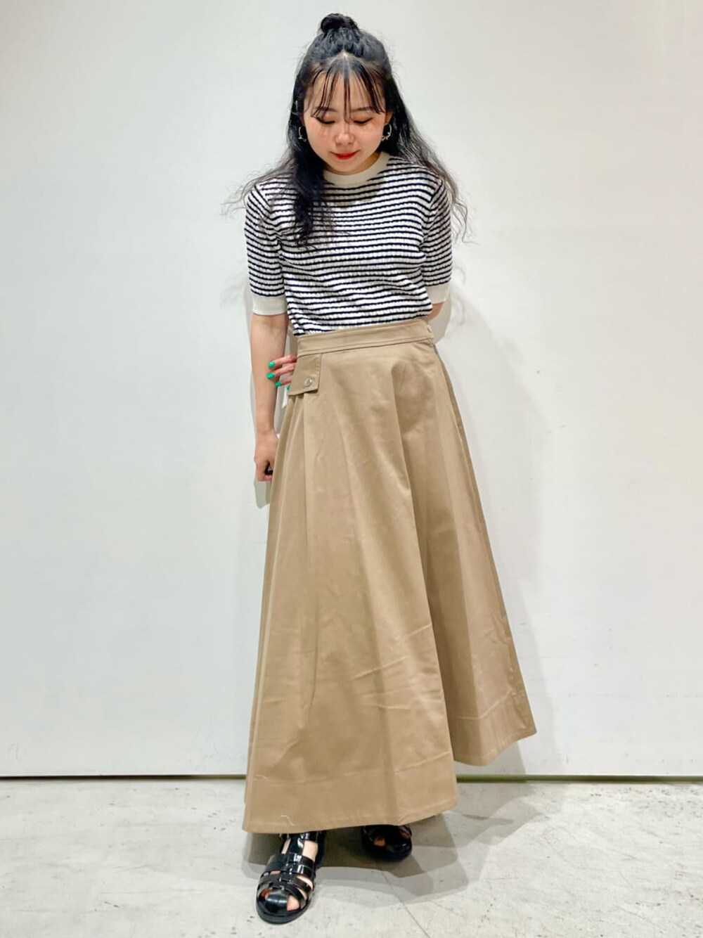 ホワイト系のニット/セーター、ベージュ系のスカート、ブラック系のサンダルを着用したレディースの夏コーディネートの1枚目の写真