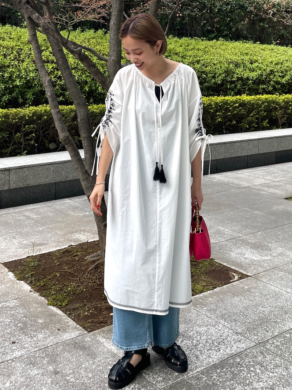 ホワイト系のワンピース、ブルー系のその他パンツ、ブラック系のサンダルを着用したレディースの春コーディネートの1枚目の写真
