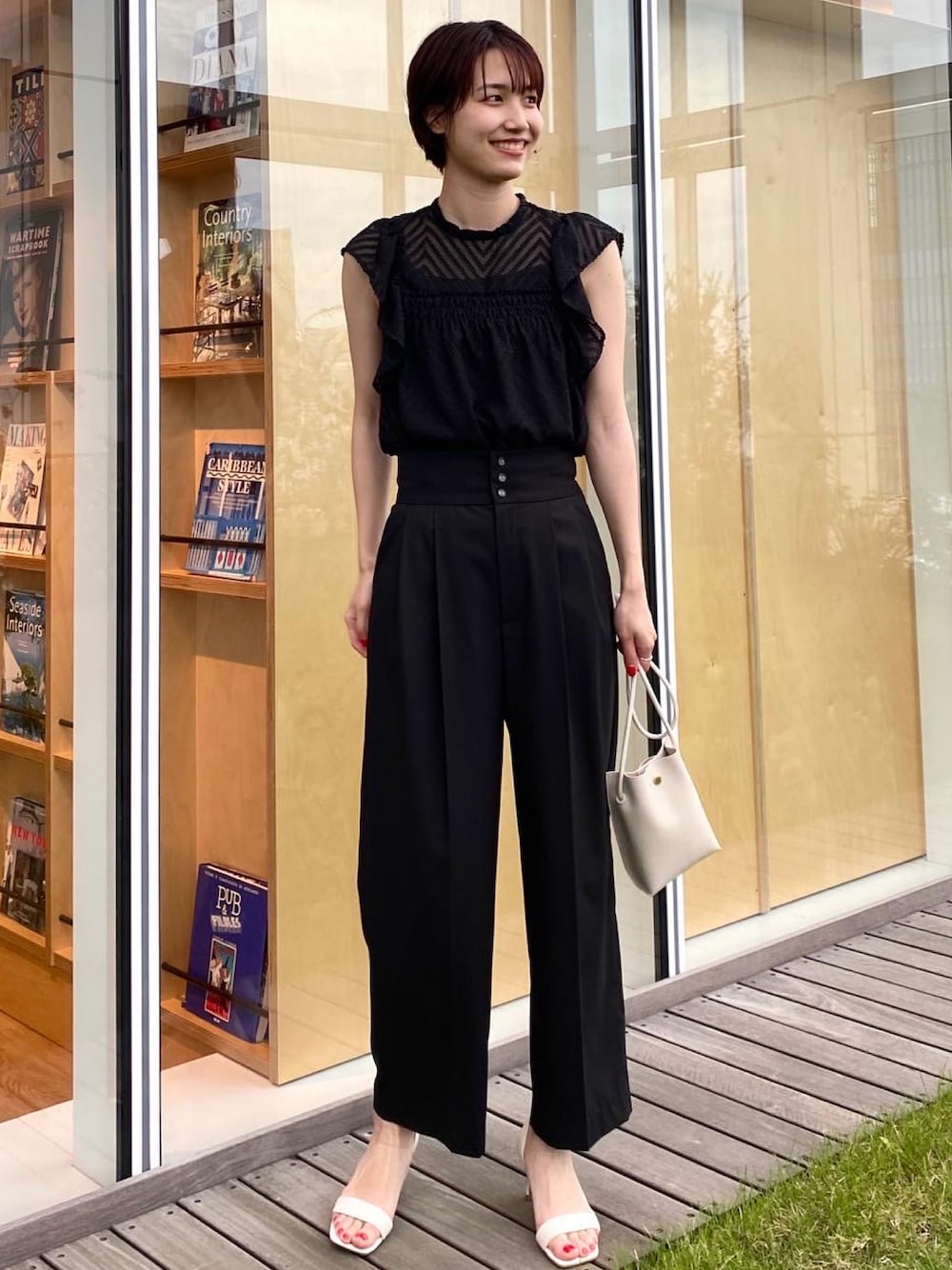 ブラック系のサロペット/オーバーオール、ブラック系のシャツ/ブラウス、ホワイト系のサンダルを着用したレディースの夏コーディネートの1枚目の写真