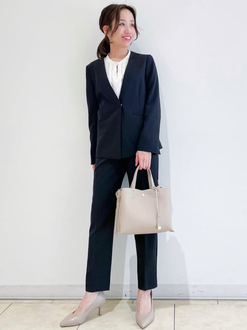 ブラック系のノーカラージャケット、ベージュ系のシャツ/ブラウス、グレー系のパンプスを着用したレディースの冬コーディネートの1枚目の写真