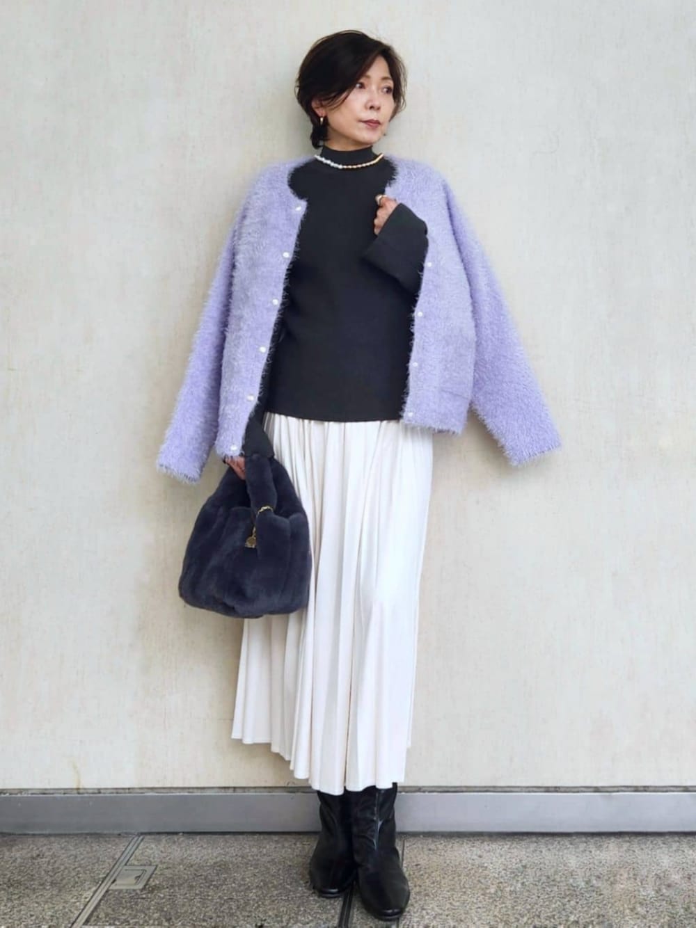 ブラック系のブーツ、パープル系のカーディガン/ボレロ、ホワイト系のスカートを着用したレディースの秋コーディネートの1枚目の写真