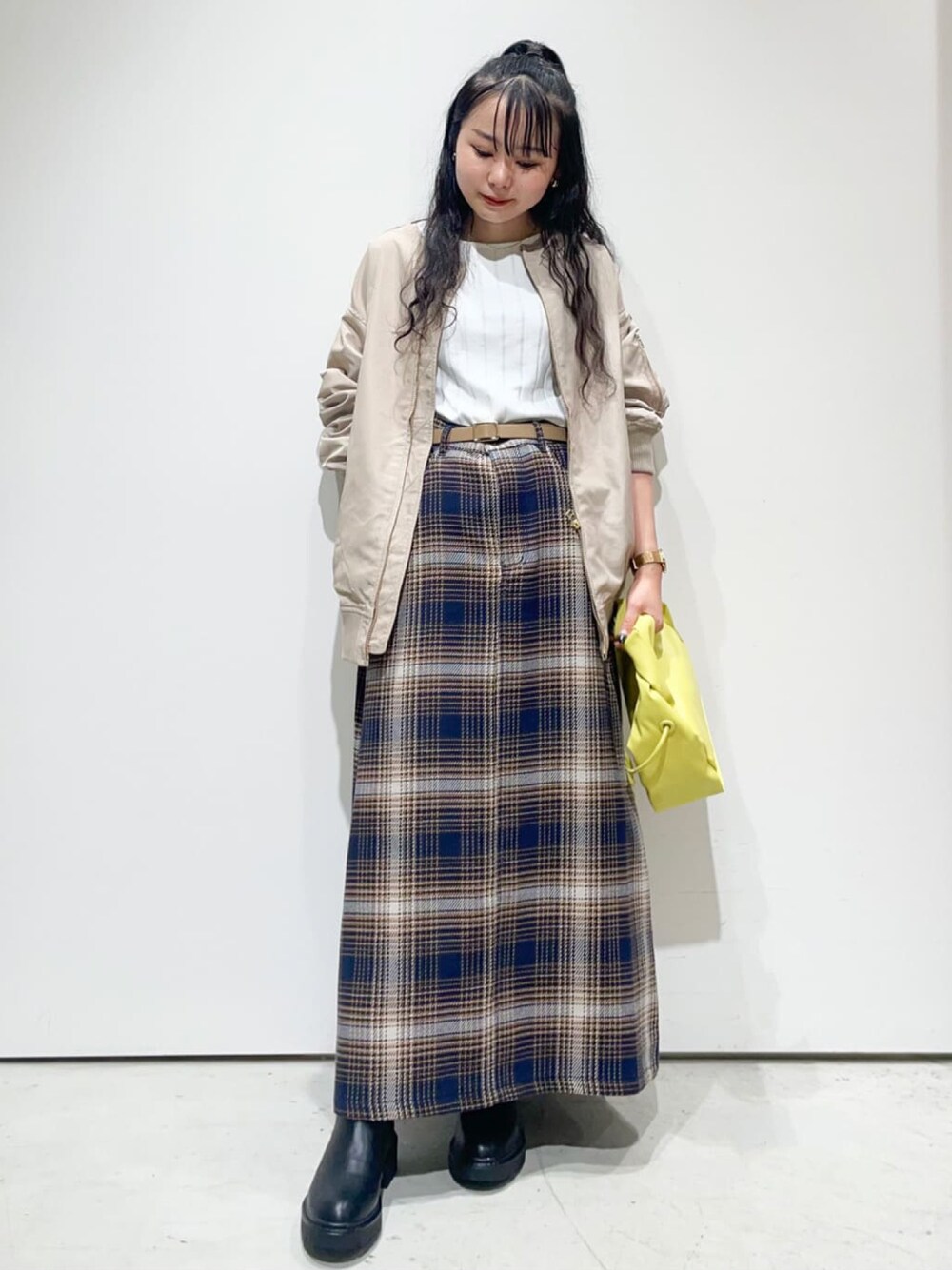 イエロー系のショルダーバッグ、ベージュ系のスカート、ホワイト系のTシャツ/カットソーを着用したレディースの秋コーディネートの1枚目の写真