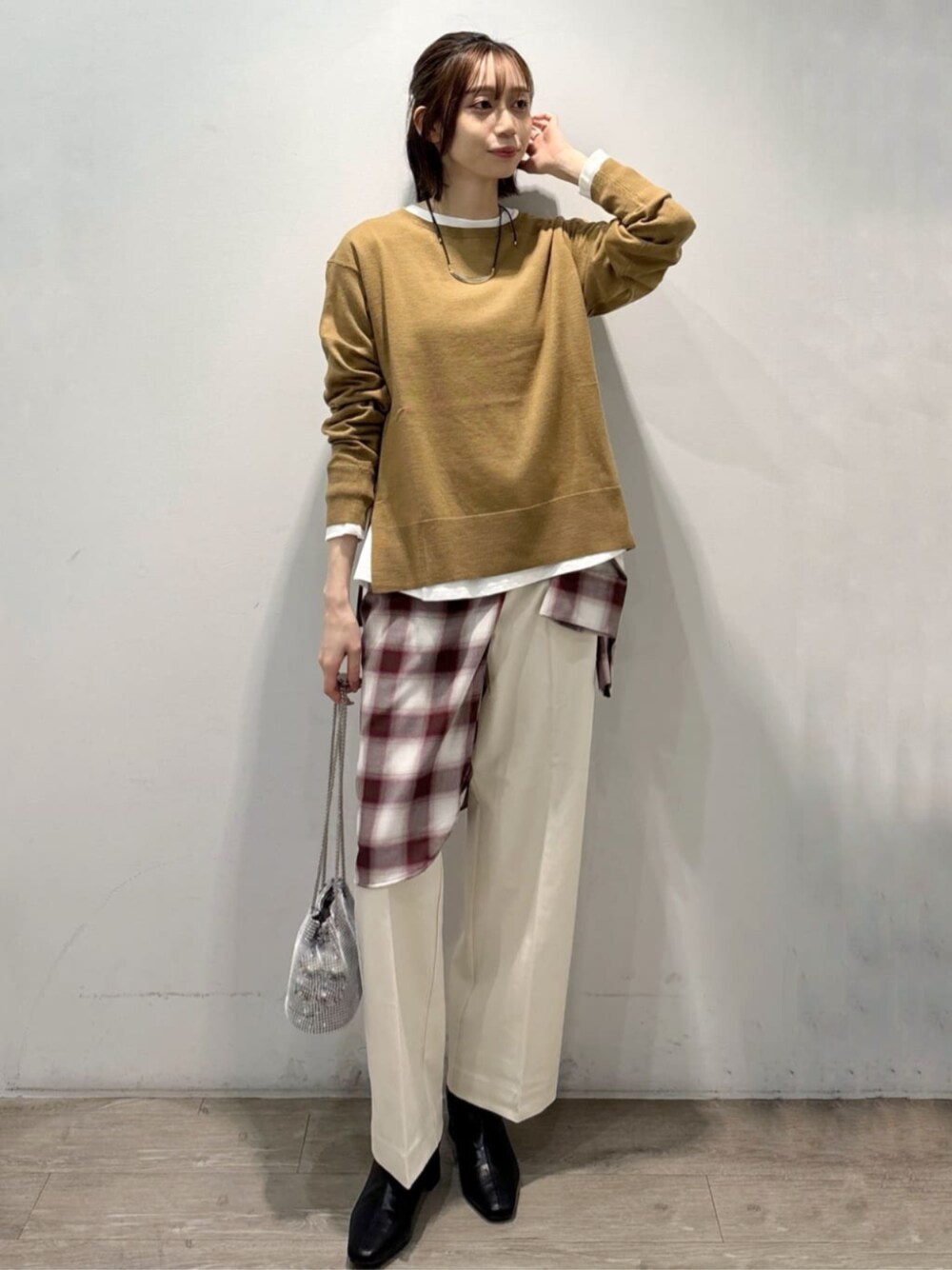 ブラック系のブーツ、イエロー系のニット/セーター、ホワイト系のTシャツ/カットソーを着用したレディースの秋コーディネートの1枚目の写真