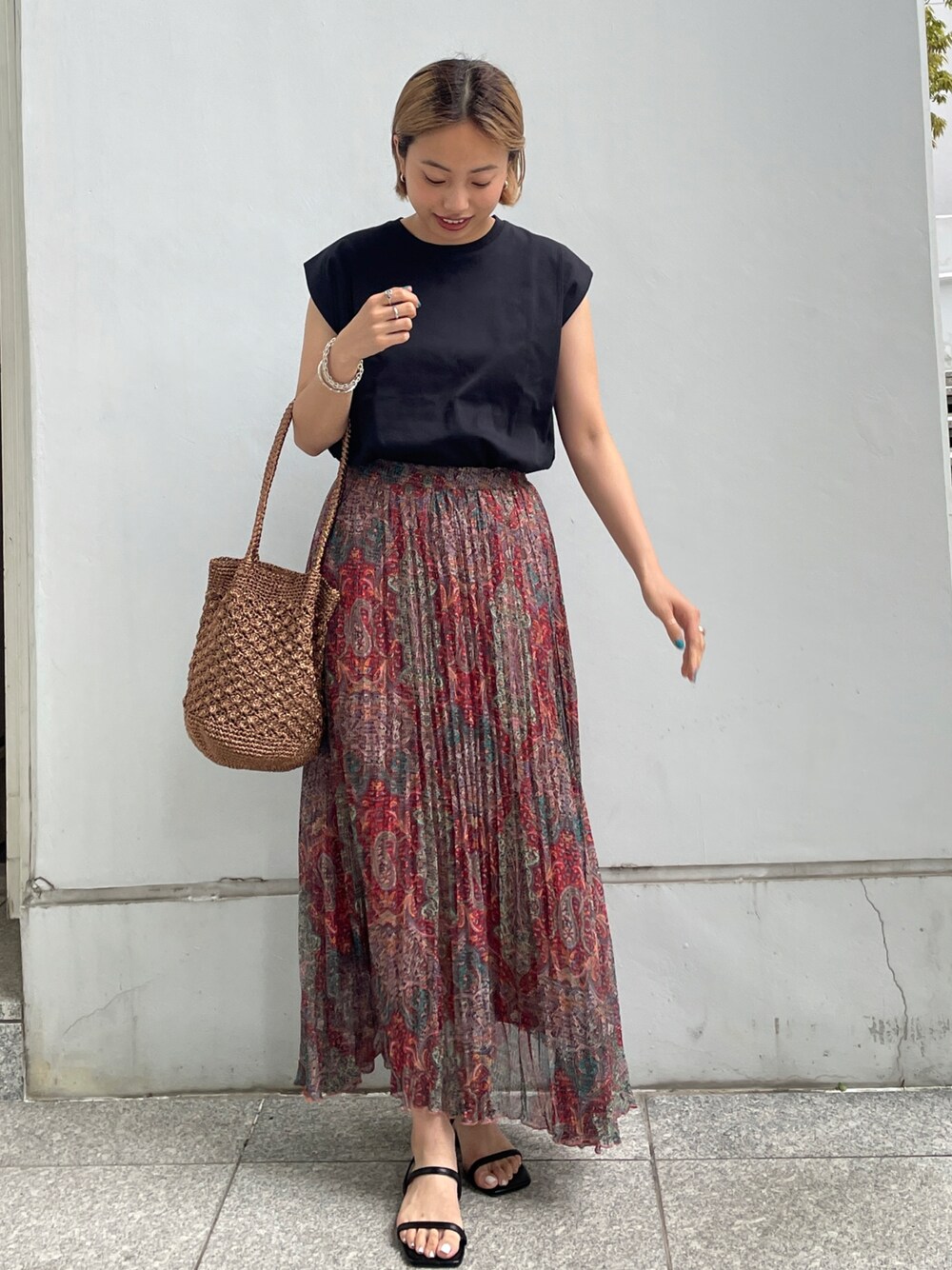 ブラック系のTシャツ/カットソー、オレンジ系のスカート、その他のトートバッグを着用したレディースの春コーディネートの1枚目の写真