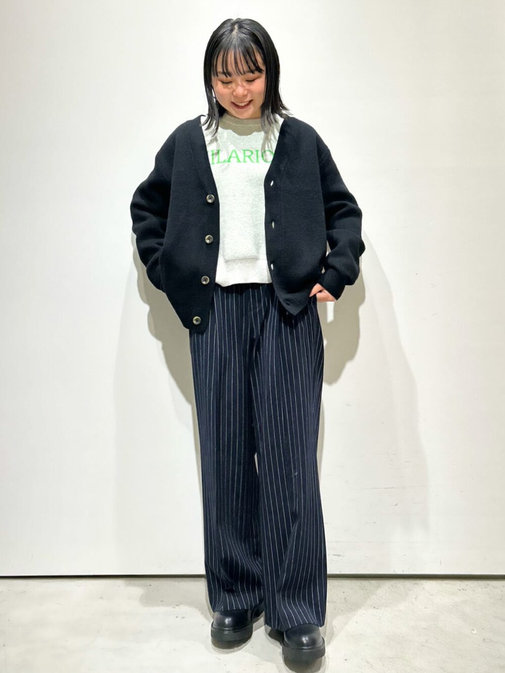ブラック系のカーディガン/ボレロ、グレー系のニット/セーター、ブラック系のブーツを着用したレディースの冬コーディネートの1枚目の写真