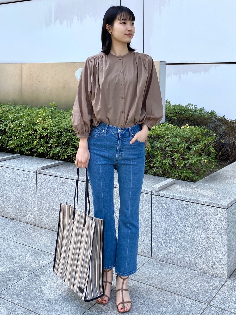 ベージュ系のシャツ/ブラウス、ブラック系のトートバッグ、ブラウン系のサンダルを着用したレディースの春コーディネートの1枚目の写真
