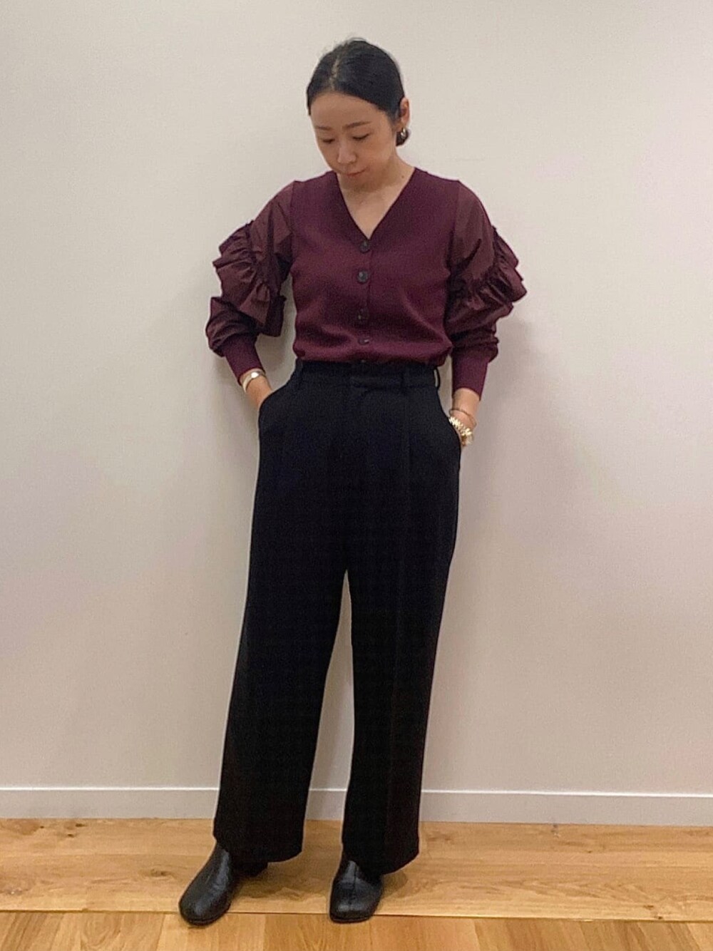 レッド系のカーディガン/ボレロ、ブラック系のその他パンツ、ブラック系のブーツを着用したレディースの秋コーディネートの1枚目の写真