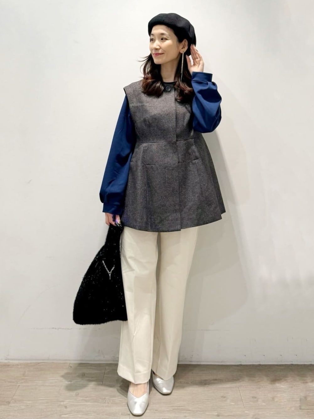 ブラック系のハンドバッグ、ホワイト系のその他パンツ、グレー系のベストを着用したレディースの秋コーディネートの1枚目の写真