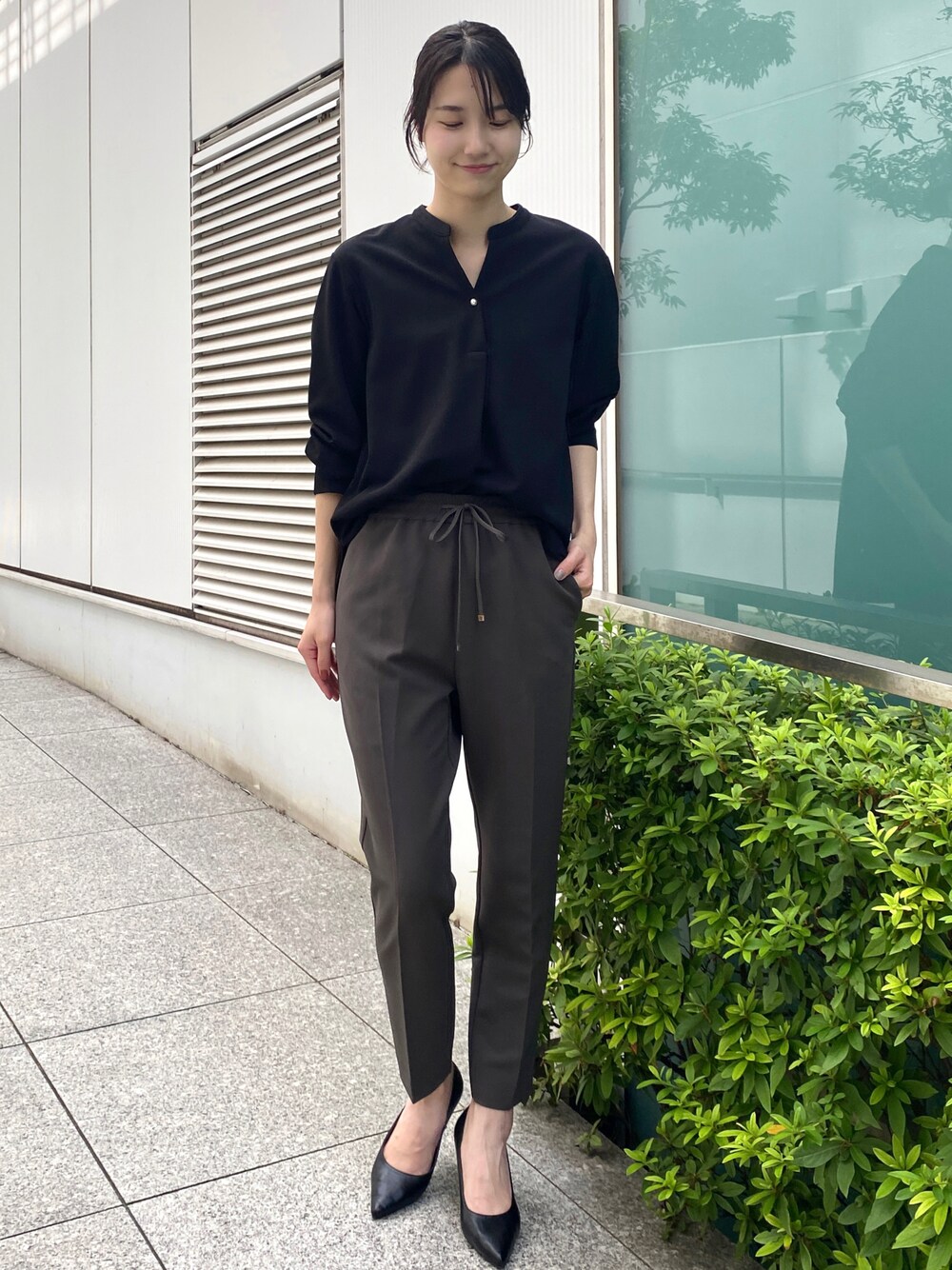 ブラック系のTシャツ/カットソー、グレー系のその他パンツ、ブラック系のパンプスを着用したレディースの秋コーディネートの1枚目の写真