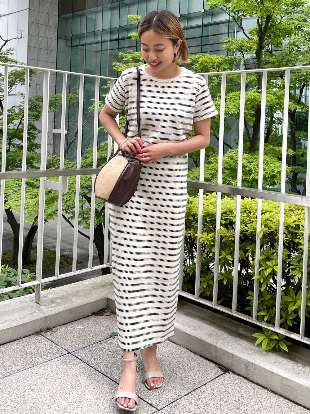 ホワイト系のTシャツ/カットソー、ホワイト系のスカート、ブラウン系のショルダーバッグを着用したレディースの夏コーディネートの1枚目の写真