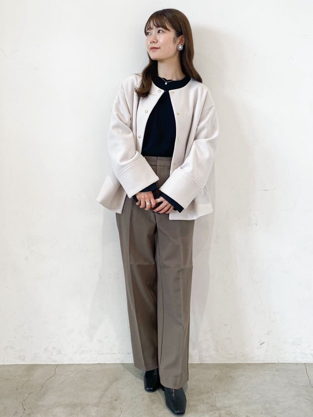 ブラウン系のその他パンツ、ベージュ系のノーカラーコート、ブラック系のニット/セーターを着用したレディースの秋コーディネートの1枚目の写真