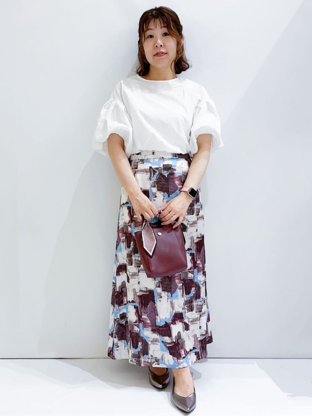 ホワイト系のシャツ/ブラウス、レッド系のスカート、レッド系のショルダーバッグを着用したレディースの夏コーディネートの1枚目の写真