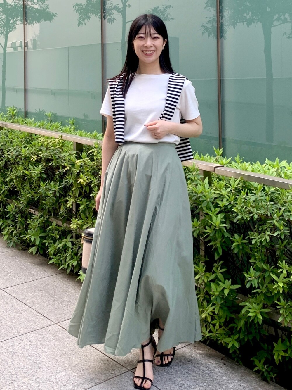 ホワイト系のTシャツ/カットソー、ホワイト系のカーディガン/ボレロ、グリーン系のスカートを着用したレディースの春コーディネートの1枚目の写真