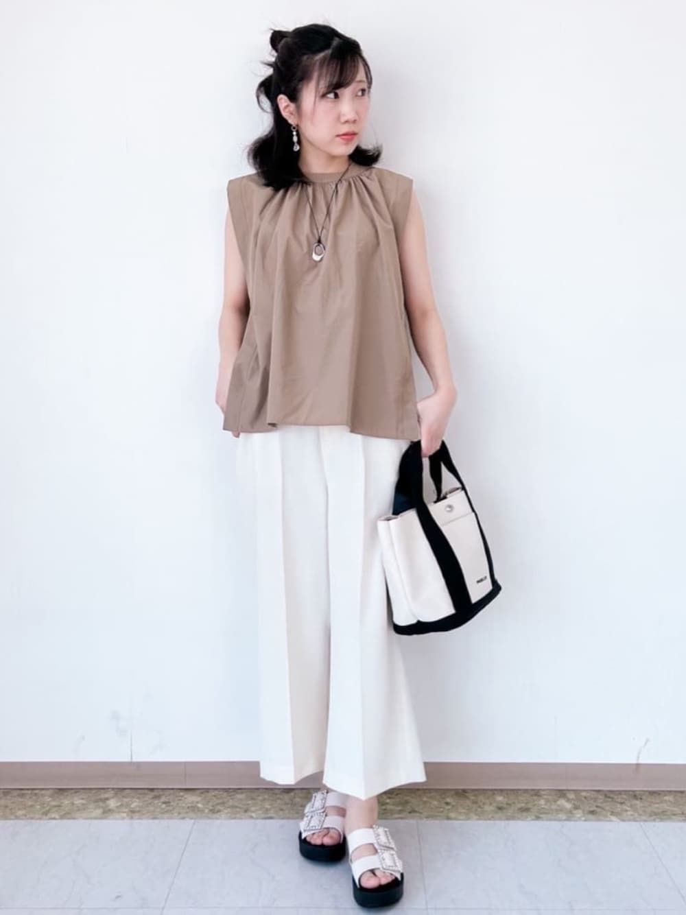 ベージュ系のシャツ/ブラウス、ホワイト系のその他パンツ、ブラック系のトートバッグを着用したレディースの夏コーディネートの1枚目の写真