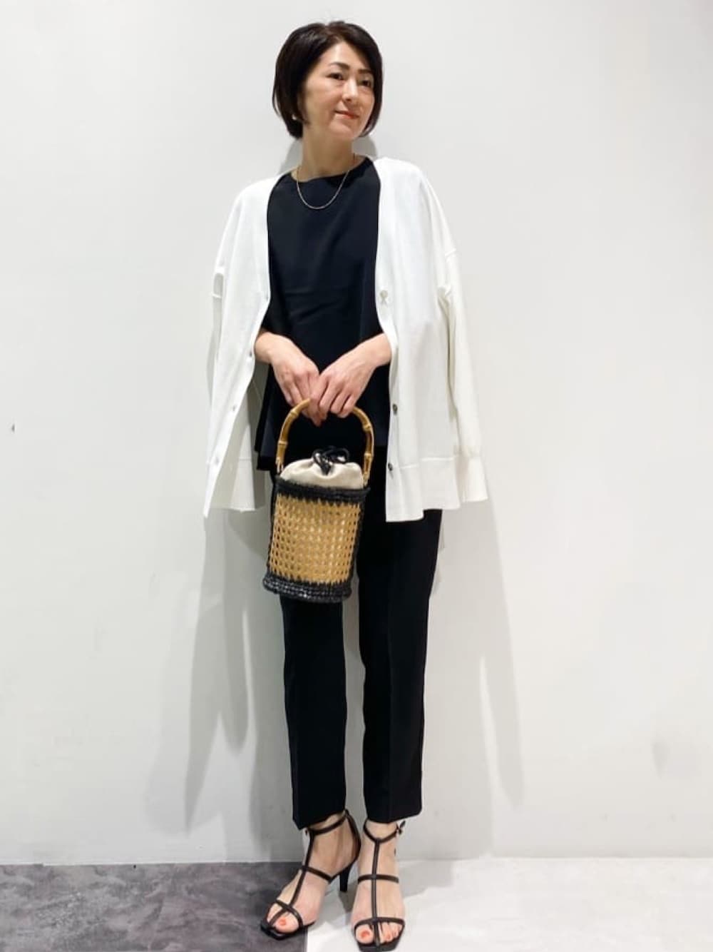 ブラック系のその他パンツ、ブラック系のシャツ/ブラウス、ホワイト系のカーディガン/ボレロを着用したレディースの春コーディネートの1枚目の写真