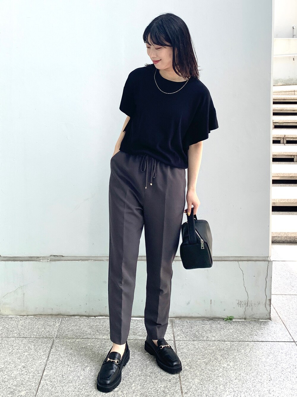 ブラック系のニット/セーター、ブラック系のその他パンツ、ブラック系のシューズを着用したレディースの夏コーディネートの1枚目の写真