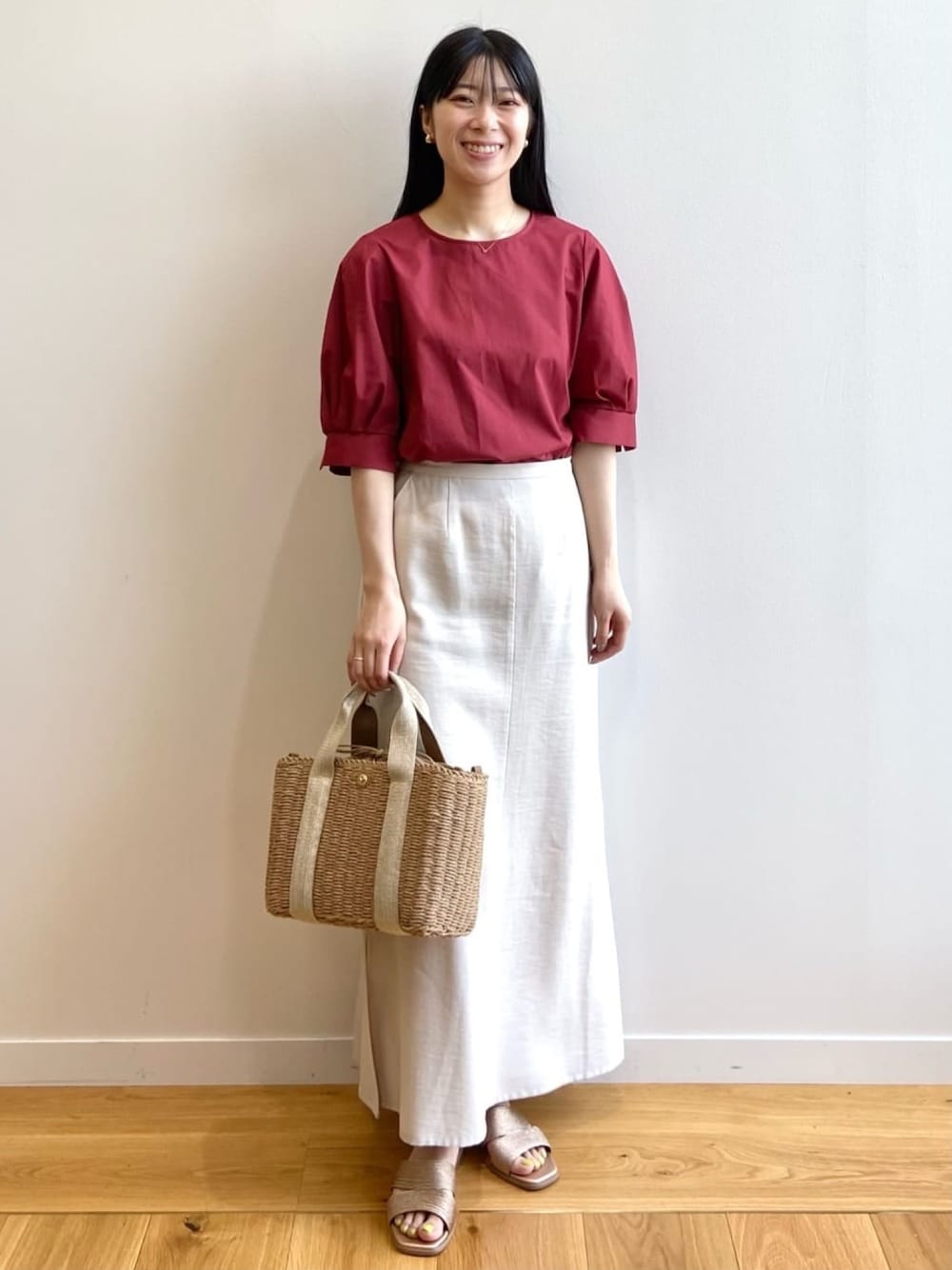 レッド系のシャツ/ブラウス、ベージュ系のスカート、ゴールド系のトートバッグを着用したレディースの夏コーディネートの1枚目の写真