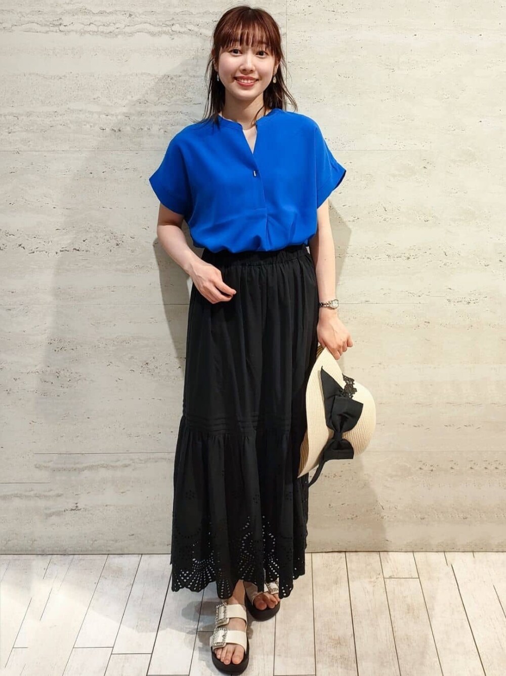 ブルー系のシャツ/ブラウス、ブラック系のスカート、ホワイト系のサンダルを着用したレディースの春コーディネートの1枚目の写真