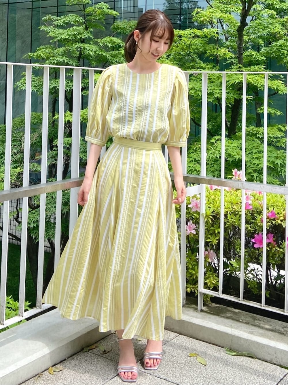 イエロー系のシャツ/ブラウス、イエロー系のスカート、シルバー系のサンダルを着用したレディースの春コーディネートの1枚目の写真