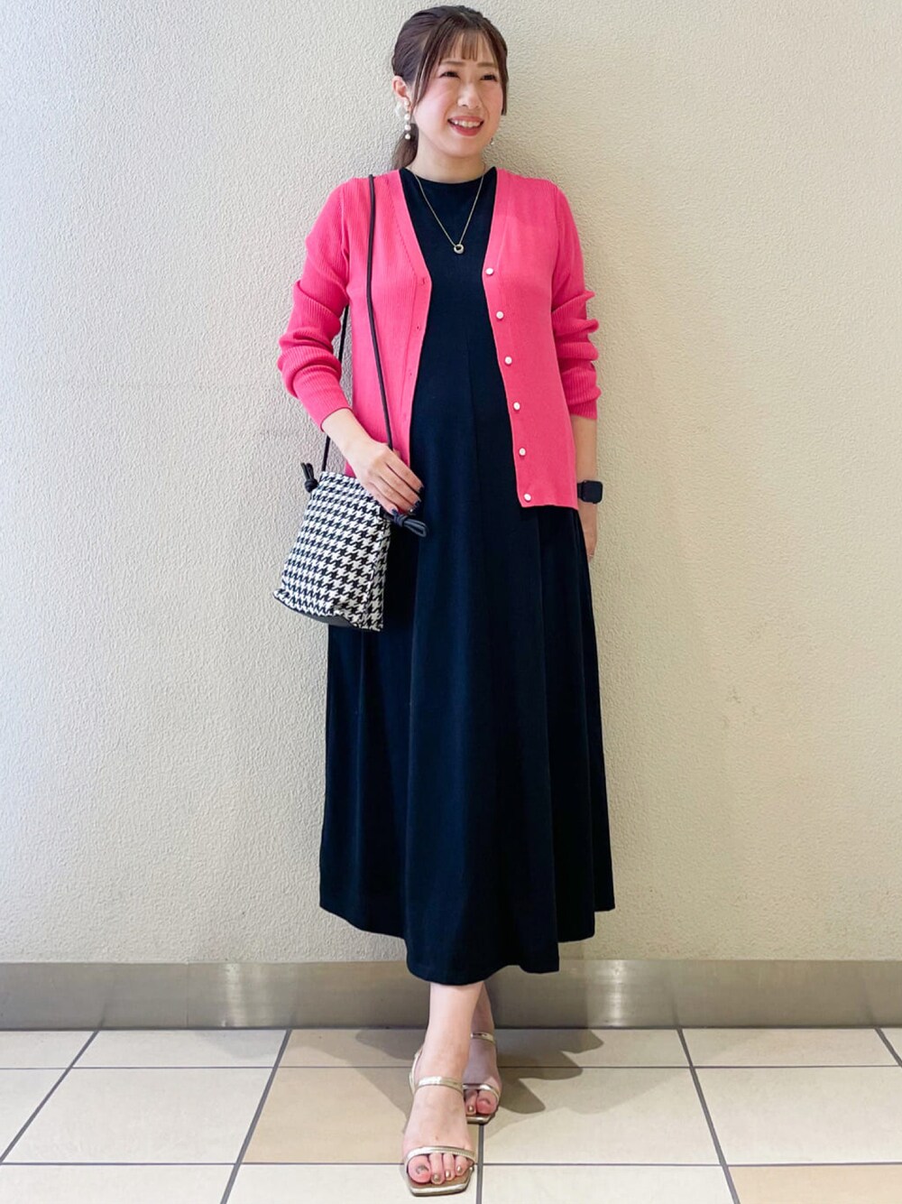 ピンク系のカーディガン/ボレロ、ブラック系のワンピース、ブラック系のショルダーバッグを着用したレディースの夏コーディネートの1枚目の写真
