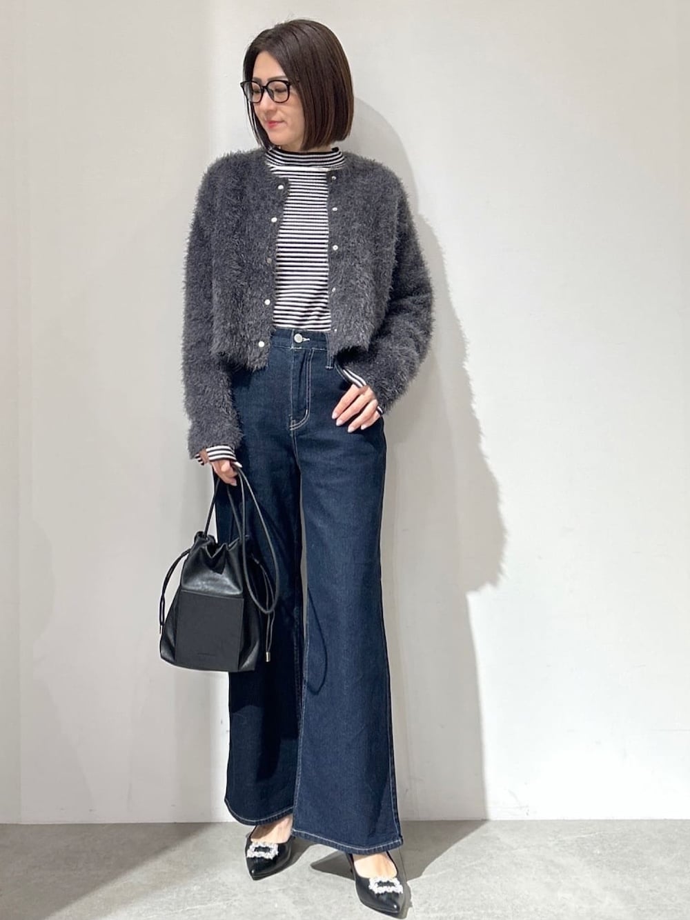 グレー系のカーディガン/ボレロ、ブルー系のその他パンツ、ブラック系のショルダーバッグを着用したレディースの冬コーディネートの1枚目の写真