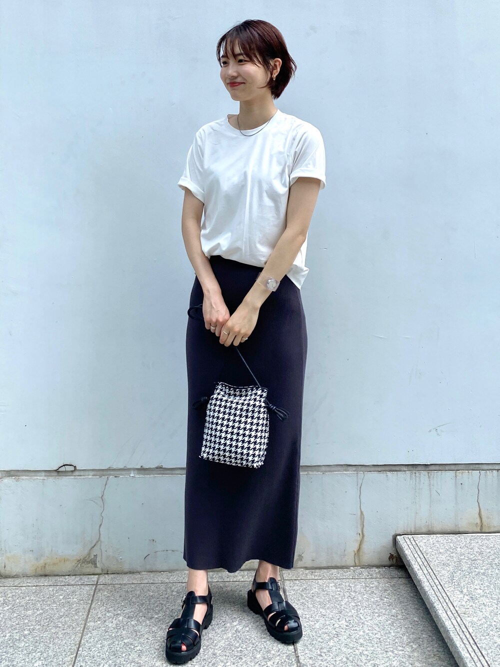 ホワイト系のTシャツ/カットソー、グレー系のスカート、ブラック系のショルダーバッグを着用したレディースの夏コーディネートの1枚目の写真