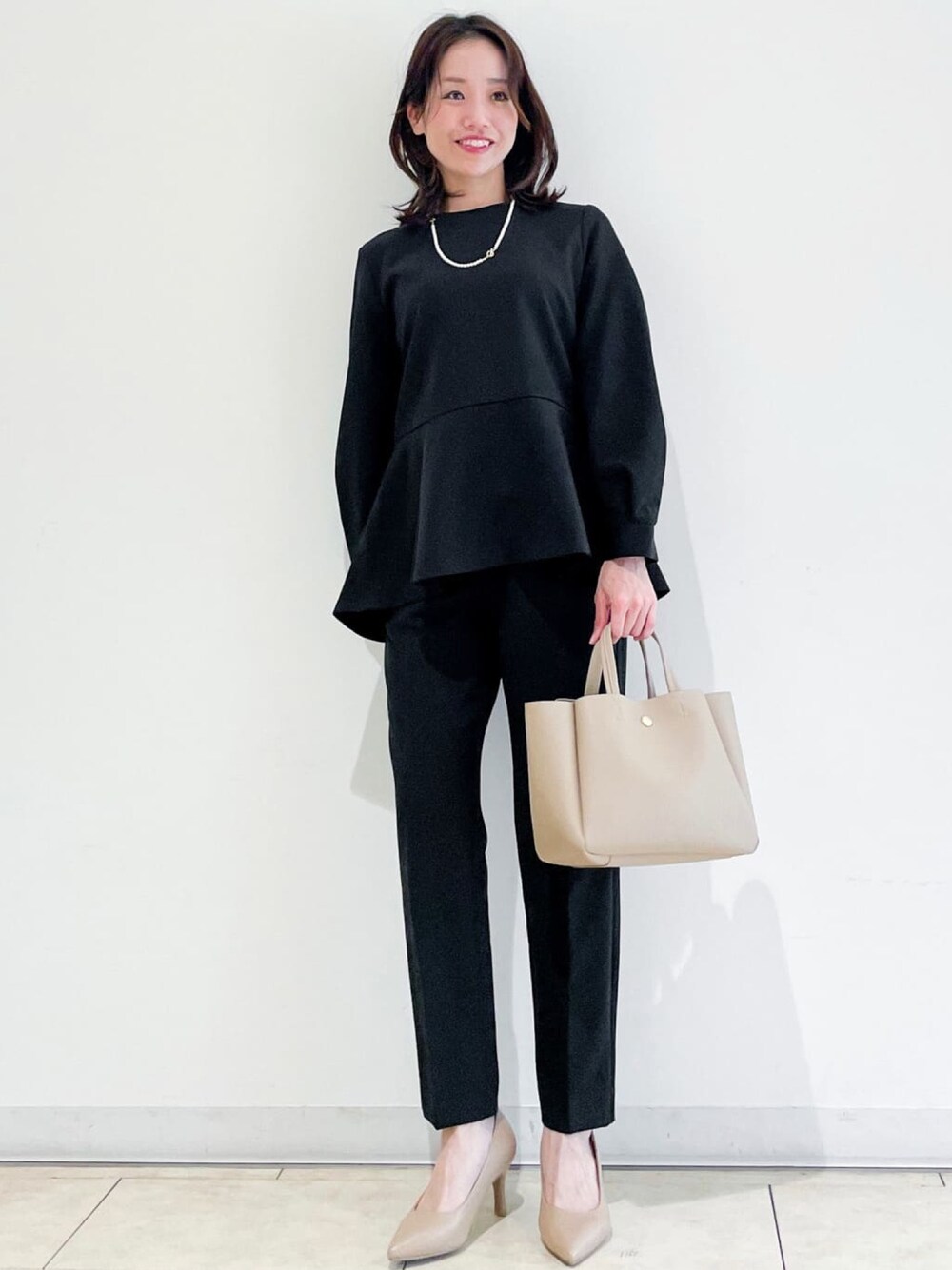 ブラック系のシャツ/ブラウス、ブラック系のその他パンツ、ベージュ系のトートバッグを着用したレディースの冬コーディネートの1枚目の写真