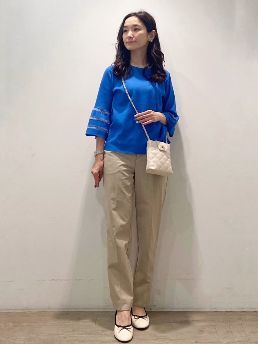 ベージュ系のその他パンツ、ブルー系のニット/セーターを着用したレディースの春コーディネートの1枚目の写真