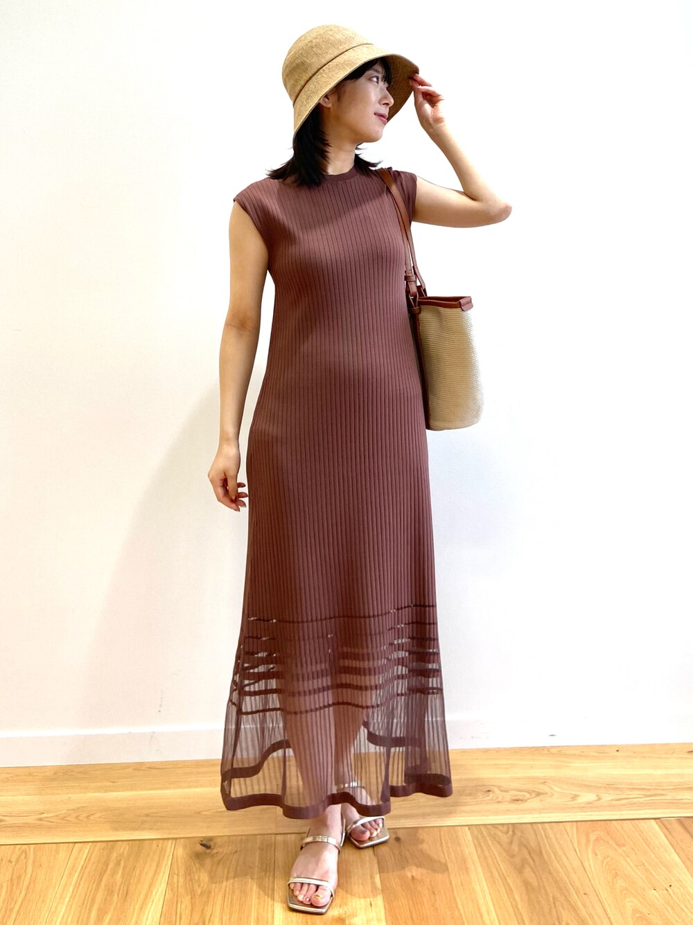 ブラウン系のワンピース、ベージュ系のトートバッグ、ゴールド系のサンダルを着用したレディースの夏コーディネートの1枚目の写真