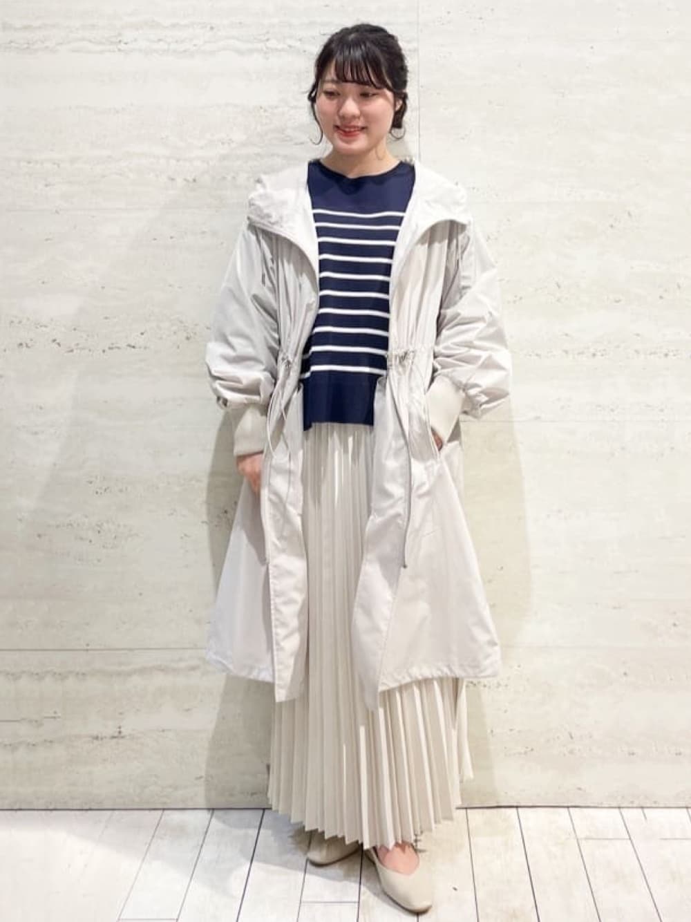 ベージュ系のその他アウター、ホワイト系のスカート、ベージュ系のパンプスを着用したレディースの春コーディネートの1枚目の写真