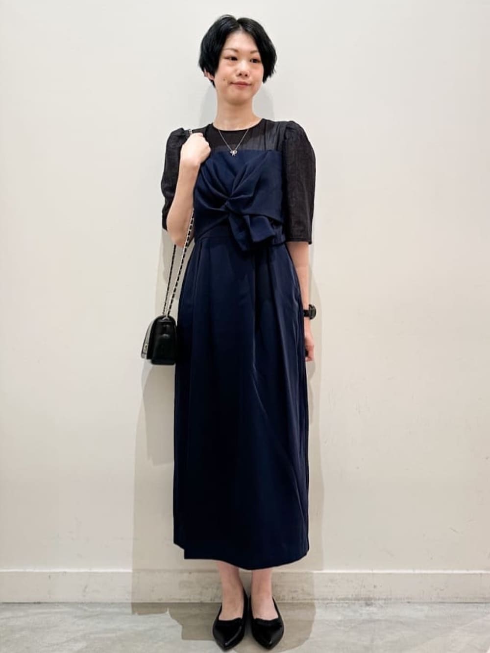 ブラック系のショルダーバッグ、ブラック系のその他シューズ、ブルー系のワンピースを着用したレディースの秋コーディネートの1枚目の写真