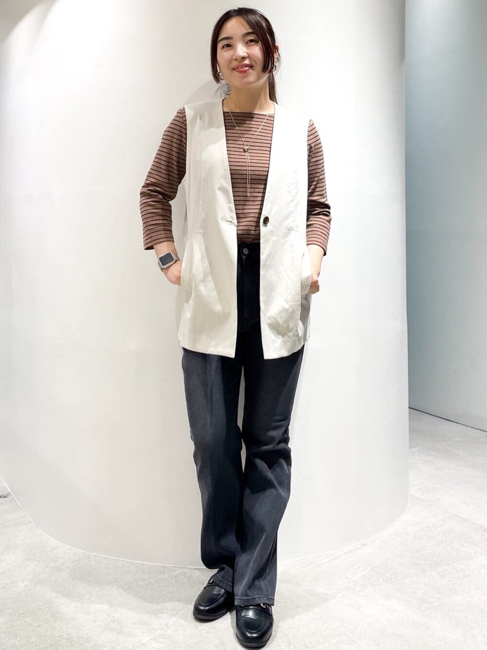 ブラック系のドレスシューズ、ブラック系のデニムパンツ、ホワイト系のベストを着用したレディースの夏コーディネートの1枚目の写真