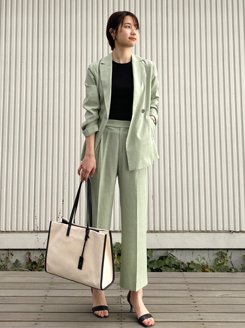 グリーン系のテーラードジャケット、グリーン系のその他パンツ、ブラック系のタンクトップを着用したレディースの春コーディネートの1枚目の写真