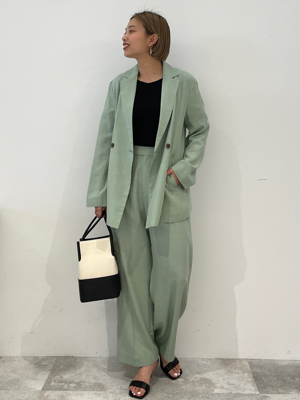 ブラック系のニット/セーター、グリーン系のテーラードジャケット、グリーン系のその他パンツを着用したレディースの春コーディネートの1枚目の写真