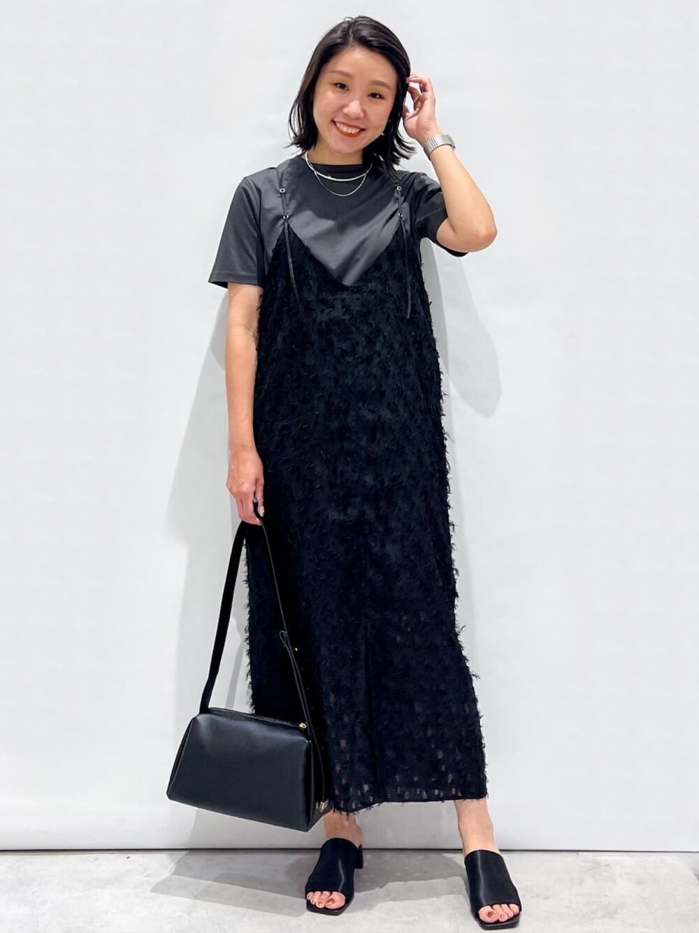 ブラック系のサンダル、ブラック系のショルダーバッグ、ブラック系のワンピースを着用したレディースの夏コーディネートの1枚目の写真